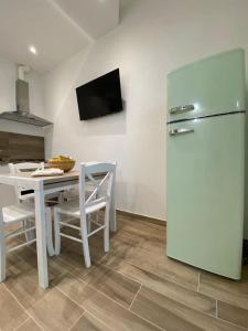 Il comprend une cuisine équipée d'une table blanche et d'un réfrigérateur. dans l'établissement 70mt dal mare, à Viareggio
