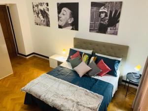 una camera da letto con letto con cuscini e poster appesi al muro di Civico 85 a Roma