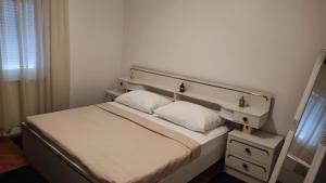ein Schlafzimmer mit einem weißen Bett mit zwei Kissen in der Unterkunft Apartments Marina Vodice in Vodice