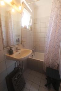 W łazience znajduje się umywalka, lustro i wanna. w obiekcie Mary's Art House in the center of Old town w Korfu