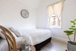 a white bedroom with a bed and a window at ‘Attunga’-1 min to Sovereign Hill, CBD, wifi, bath in Ballarat