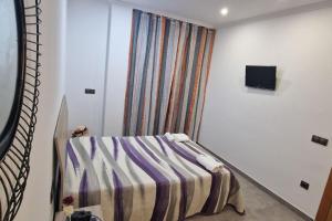 a room with a bed with a striped blanket and a window at Casa Cani in Villareal