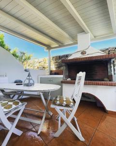 a patio with a table and chairs and a grill at Egea House in Stelida
