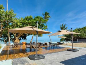 a patio with tables and chairs and umbrellas at coral coast FIJI in Sigatoka