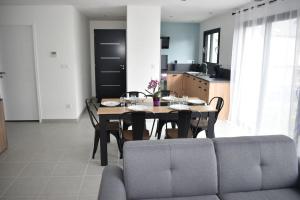 Maison climatisée accessible PMR في آرجليز - غازو: غرفة طعام مع طاولة وأريكة