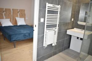 Habitación con cama y baño con espejo. en Maison climatisée accessible PMR en Argelès-Gazost