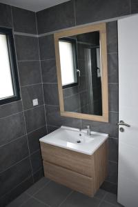y baño con lavabo y espejo. en Maison climatisée accessible PMR en Argelès-Gazost