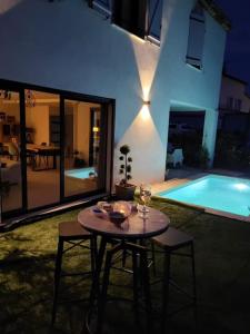 - une table et des chaises dans un jardin avec piscine dans l'établissement Maison avec piscine Côte d'Azur, à Auribeau-sur-Siagne