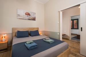 a bedroom with a large bed with two towels on it at Isabella's Hidden Gem House in Chania Town