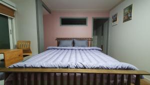 a bedroom with a large bed with white sheets at Yachtie Inn Yudal in Mokpo