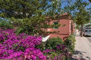 a pink building with purple flowers in front of it at Isabella's Hidden Gem House in Chania Town