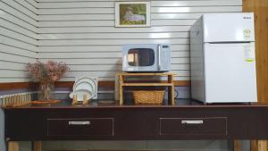 a table with a microwave and a refrigerator at Yachtie Inn Yudal in Mokpo