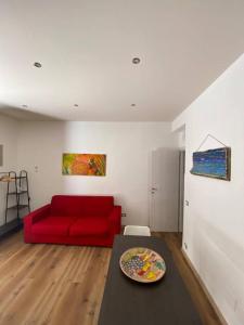 sala de estar con sofá rojo y mesa en The First apartment en Cinisi