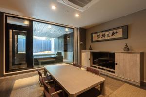 uma sala de jantar com uma mesa e uma lareira em KANAYA RESORT HAKONE em Hakone