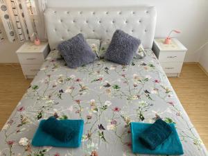 - une chambre avec un grand lit et des oreillers bleus dans l'établissement Apartamani Evelin, à Veliko Gradište
