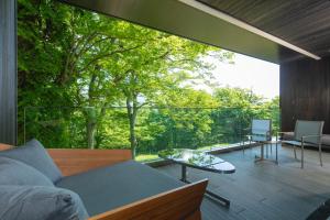 KANAYA RESORT HAKONE في هاكوني: غرفة معيشة مع أريكة وطاولة زجاجية