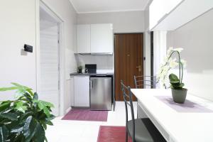 a kitchen with white cabinets and a stainless steel refrigerator at Lake House Valeriana in Pilzone