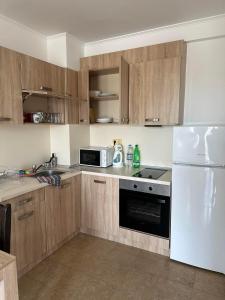 eine Küche mit Holzschränken und einem weißen Kühlschrank in der Unterkunft Elizabeth Dy Boutique Hotel in Nessebar