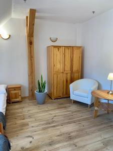 a bedroom with a blue chair and a wooden cabinet at Gościniec Rzemyk in Wdzydze Kiszewskie