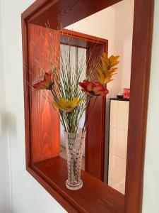a vase with flowers in front of a mirror at Apartment Leda in Kraljevica