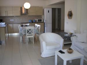 a living room and kitchen with a couch and a table at Kosher Tersefanou Larnaca in Larnaka