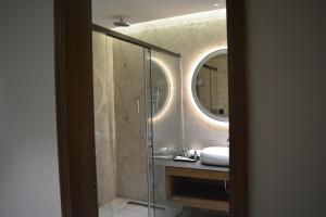 a bathroom with a shower with a sink and a mirror at Sayaji Morbi in Morbi