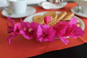 un plato de galletas y flores púrpuras en una mesa en Hotel Esperia en Capri