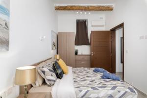 a bedroom with a bed and a lamp at Modern, Cosy 1BD Apartment - Close to Valletta in Hamrun