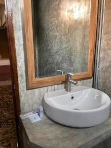 - białą umywalkę w łazience z lustrem w obiekcie Vintage54 Hotel Ayutthaya w mieście Phra Nakhon Si Ayutthaya