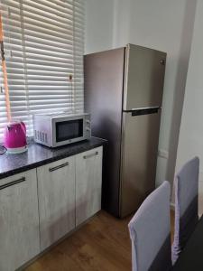 a kitchen with a microwave and a refrigerator at Zyli Apts, BY Bunker Art 2 Museum, Tirana in Tirana