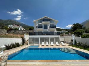 a house with a swimming pool in front of a house at Paris A Villa, Özel Havuzlu, Fethiye in Fethiye