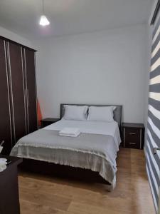 a bedroom with a bed with white sheets and pillows at Zyli Apts, BY Bunker Art 2 Museum, Tirana in Tirana