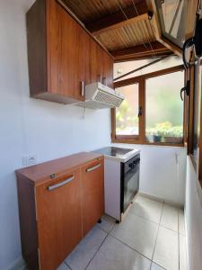 a kitchen with wooden cabinets and a stove top oven at Zyli Apts, BY Bunker Art 2 Museum, Tirana in Tirana