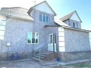 a blue bike parked in front of a house at Guest house Ayperi in Bokonbayevo