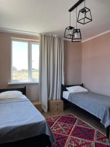 sypialnia z 2 łóżkami i oknem w obiekcie Guest house Hygge w mieście Czołponata