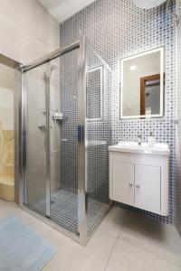 uma casa de banho com um chuveiro e um lavatório. em Modern, Cosy 1BD Apartment - Close to Valletta em Hamrun