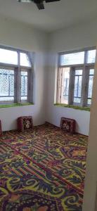 an empty room with two chairs and two windows at POP Masrat Homestay 