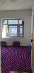 une pièce vide avec deux chaises et une grande fenêtre dans l'établissement POP Masrat Homestay, 