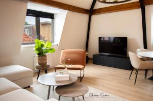 een woonkamer met een bank en een tv bij ApartHotel De Koning by Urban Home Stay in Alkmaar
