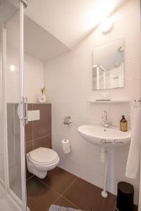 uma casa de banho branca com um WC e um lavatório em ApartHotel De Koning by Urban Home Stay em Alkmaar