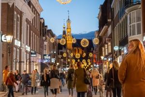 una multitud de personas caminando por una calle con luces de Navidad en ApartHotel De Koning by Urban Home Stay, en Alkmaar