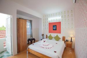 1 dormitorio con 1 cama blanca grande en una habitación en Cua Dai Beach Homestay en Hoi An