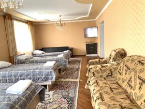 Zimmer mit 2 Betten, einem Sofa und einem TV in der Unterkunft Guest house Ayperi in Bokonbayevo