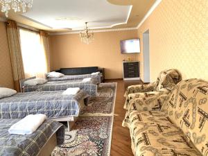 Pokój z dwoma łóżkami, kanapą i telewizorem w obiekcie Guest house Ayperi w mieście Bokonbayevo