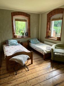 um quarto com 2 camas, uma cadeira e 2 janelas em Przytulne Siedlisko em Jugowice