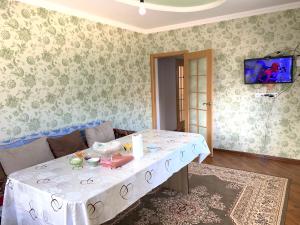 salon ze stołem z białą tkaniną w obiekcie Guest house Ayperi w mieście Bokonbayevo
