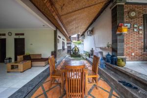 eine Terrasse mit einem Tisch, Stühlen und einem Sofa in der Unterkunft Made Arsa Homestay in Ubud