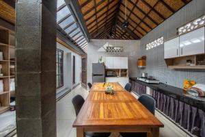 eine große Küche mit einem Holztisch und Stühlen in der Unterkunft Made Arsa Homestay in Ubud