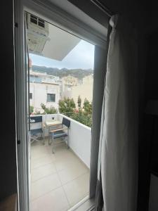 Blick auf einen Balkon mit einem Tisch und einem Fenster in der Unterkunft Studio in the center, 2 mins from the beach in Loutraki