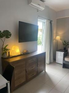 uma sala de estar com uma televisão de ecrã plano na parede em Studio in the center, 2 mins from the beach em Loutraki